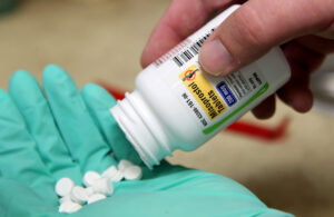 A pharmacist poses with pills of the drug Misoprostol, made by Lupin Pharmaceuticals, in his hand at a pharmacy in Provo